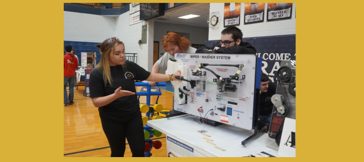 Automotive students explain a car wiper assembly.
